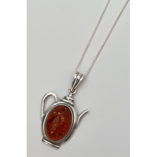 90 - A silver and amber pendant in the shape of a teapot, on a 16