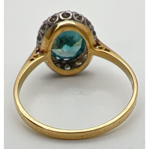 97 - An 18ct gold halo set London blue topaz and diamond dress ring. Large oval cut central topaz stone, ... 