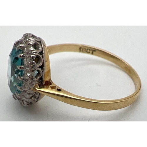 97 - An 18ct gold halo set London blue topaz and diamond dress ring. Large oval cut central topaz stone, ... 