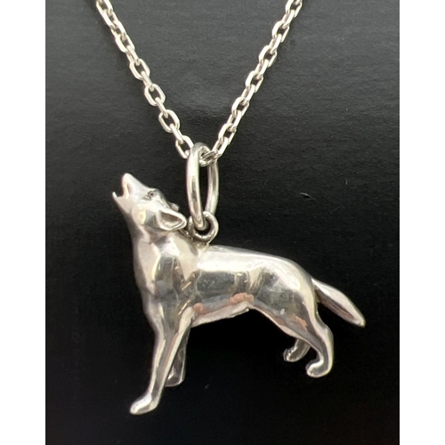 99 - A white metal pendant modelled as a howling dog/wolf, on a  21