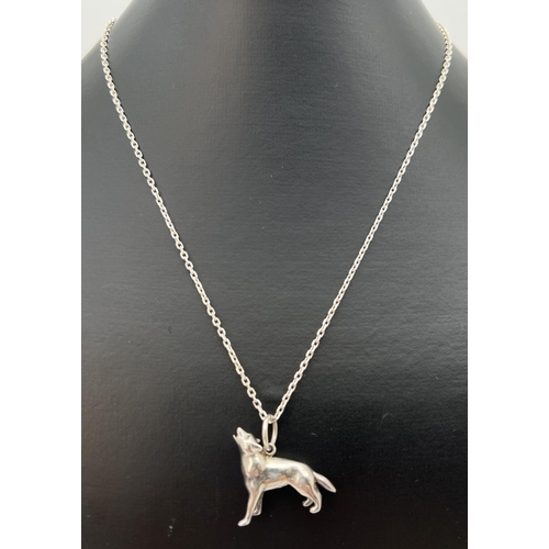 99 - A white metal pendant modelled as a howling dog/wolf, on a  21