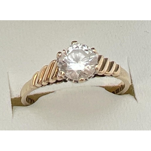 101 - A vintage 9ct gold clear stone solitaire ring with twisted design to shoulders. Fully hallmarked ins... 