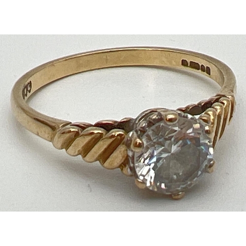 101 - A vintage 9ct gold clear stone solitaire ring with twisted design to shoulders. Fully hallmarked ins... 