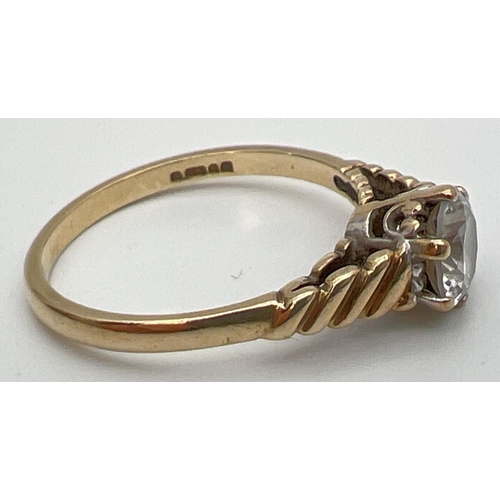 101 - A vintage 9ct gold clear stone solitaire ring with twisted design to shoulders. Fully hallmarked ins... 