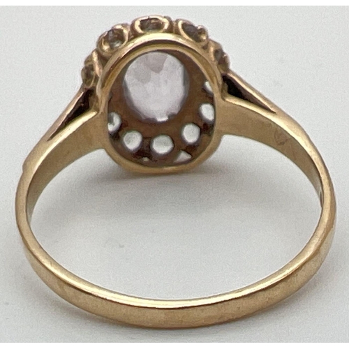 102 - A vintage 9ct gold halo set ring with central oval cut Rose de France stone. Surrounded by 12 cubic ... 