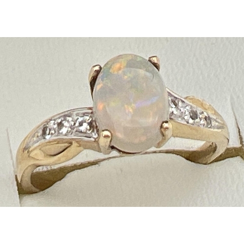 106 - A 9ct gold modern design ring set with central oval opal and 3 white topaz stones to each shoulder. ... 