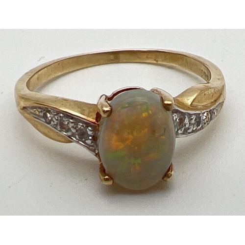 106 - A 9ct gold modern design ring set with central oval opal and 3 white topaz stones to each shoulder. ... 