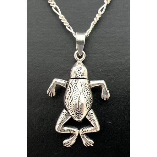 111 - A silver articulated frog pendant on a 17