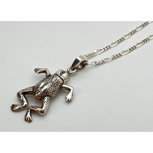 111 - A silver articulated frog pendant on a 17