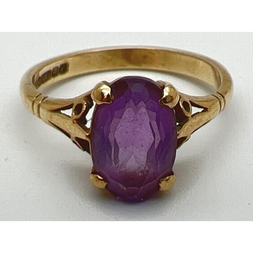 115 - A 9ct gold and amethyst dress ring with large oval cut stone and decorative shoulders. Stone approx.... 