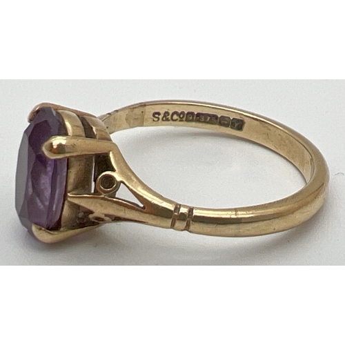 115 - A 9ct gold and amethyst dress ring with large oval cut stone and decorative shoulders. Stone approx.... 