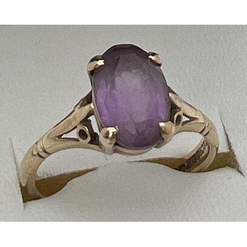 115 - A 9ct gold and amethyst dress ring with large oval cut stone and decorative shoulders. Stone approx.... 