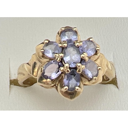 118 - A 9ct gold and tanzanite dress ring in a flower shaped setting of 7 oval cut stones. Stamped 9k insi... 