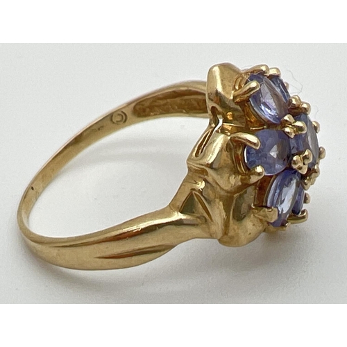 118 - A 9ct gold and tanzanite dress ring in a flower shaped setting of 7 oval cut stones. Stamped 9k insi... 