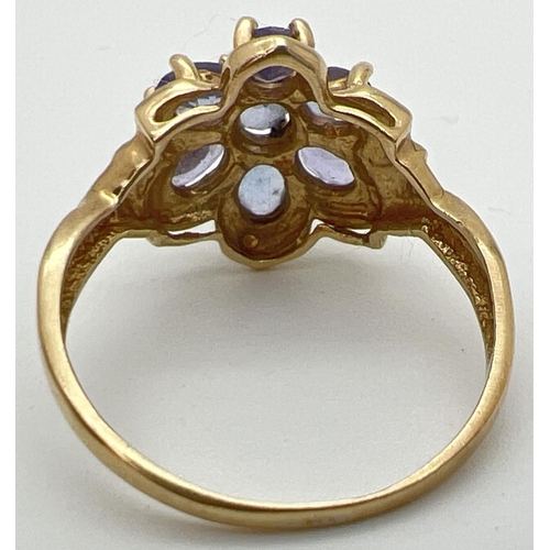 118 - A 9ct gold and tanzanite dress ring in a flower shaped setting of 7 oval cut stones. Stamped 9k insi... 