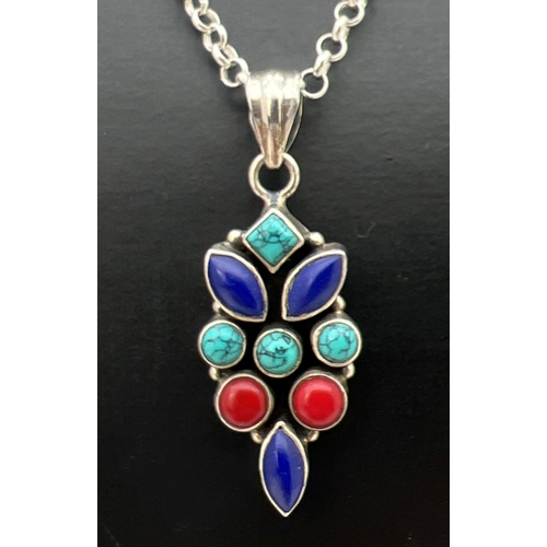 119 - A turquoise, lapis, coral and silver pendant on a 17