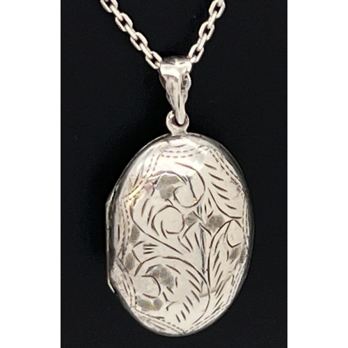 124 - A large silver oval shaped locket on an 18