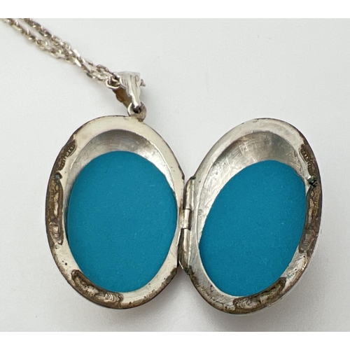 124 - A large silver oval shaped locket on an 18