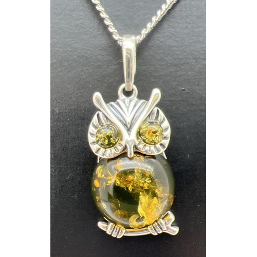 125 - A silver and green amber pendant in the form of an owl, on an 18