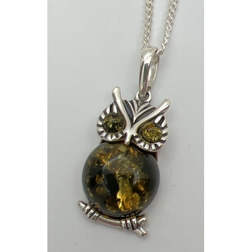 125 - A silver and green amber pendant in the form of an owl, on an 18