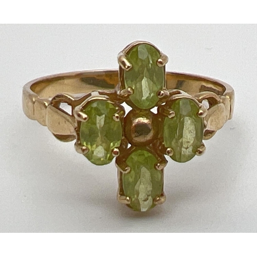 126 - A 9ct gold and peridot ring in a quatrefoil shaped setting with shaped shoulders. 4 oval cut peridot... 