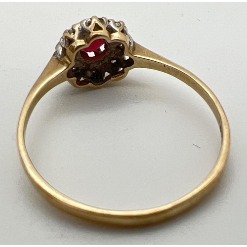 130 - A 9ct gold ruby and diamond ring in a halo style setting. Central round cut ruby surrounded by 8 ill... 