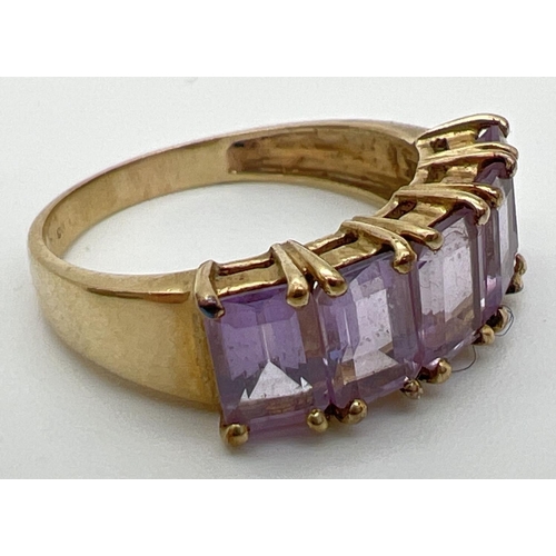 131 - A 9ct gold eternity style ring set with 5 large baguette cut amethyst stones. Each measuring approx.... 