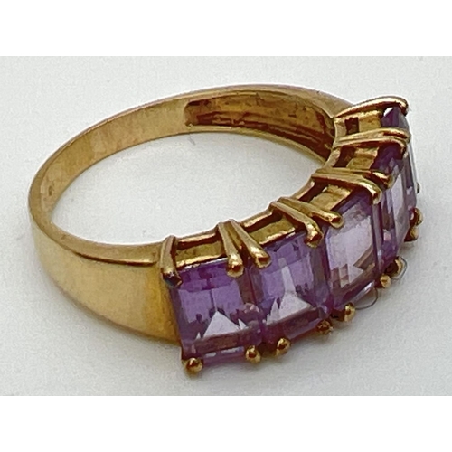 131 - A 9ct gold eternity style ring set with 5 large baguette cut amethyst stones. Each measuring approx.... 