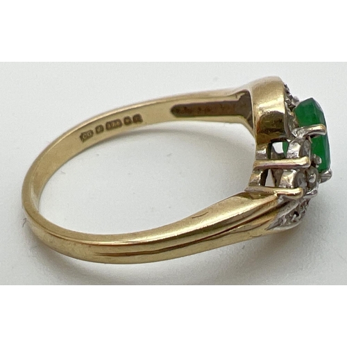 141 - A 9ct gold, emerald and diamond ring with a modern twist design setting. Central oval cut emerald wi... 