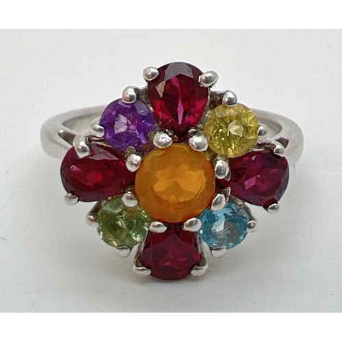 144 - A silver The Genuine Gem Company multi stone set ring, size N½. Central fire opal surrounded by garn... 