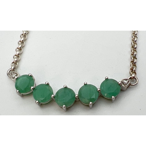 145 - A silver, emerald and diamond fixed pendant necklace with spring ring clasp. A row of 5 round cut em... 