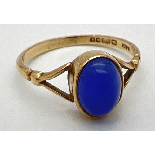 148 - A 9ct gold dress ring set with oval blue stone cabochon and shaped shoulders. Ring size M½.