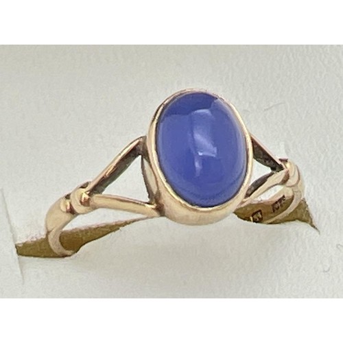 148 - A 9ct gold dress ring set with oval blue stone cabochon and shaped shoulders. Ring size M½.