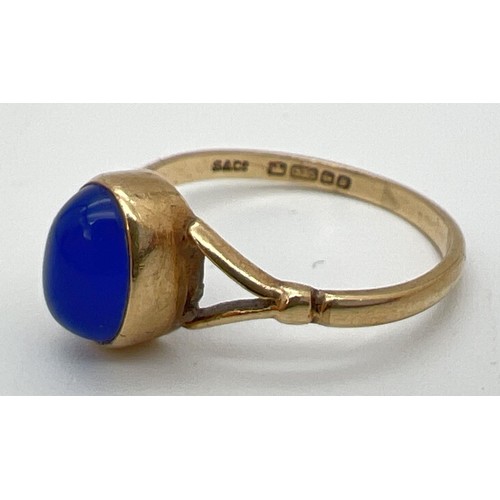 148 - A 9ct gold dress ring set with oval blue stone cabochon and shaped shoulders. Ring size M½.