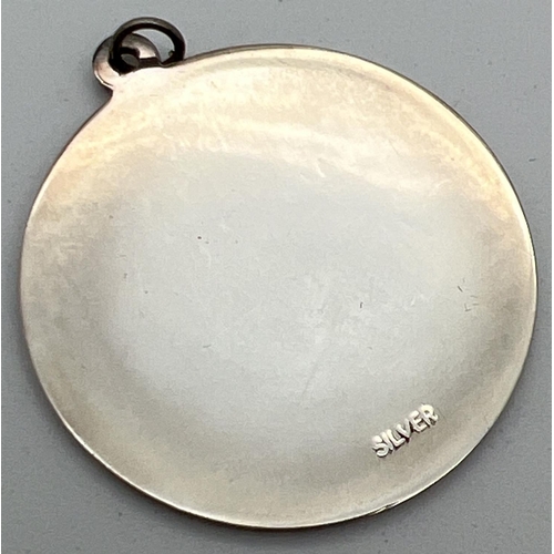 1009 - A vintage silver St. Christopher circular shaped pendant. Stamped 