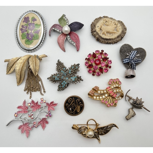 1012 - A collection of 12 vintage brooches in various designs, mostly floral and alpine themed. To include ... 