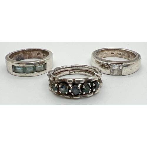 1028 - 3 silver stone set band style dress rings to include a channel set, baguette cut blue topaz ring. Si... 