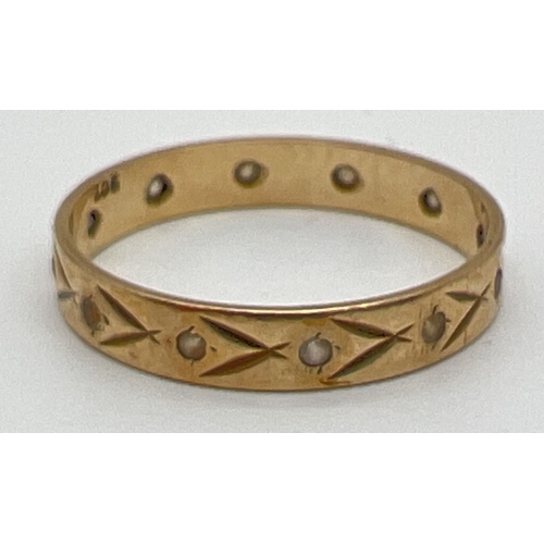 1038 - A vintage 9ct gold and clear stone set full eternity ring with floral engraved detail. Gold mark to ... 