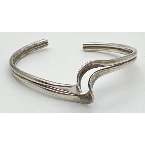 1041 - A silver wave design torque style bangle. Silver marks to inside. Total weight approx 13.1g.