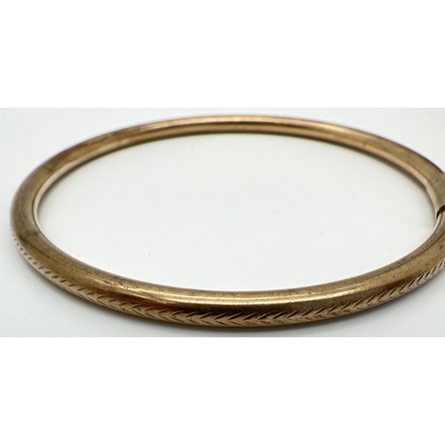 1045 - A vintage 9ct gold bangle with engraved floral pattern. Bangle has been repaired and strengthened wi... 