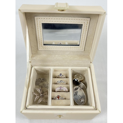 1057 - A small modern cream faux leather jewellery box with lift out tray containing a collection of silver... 