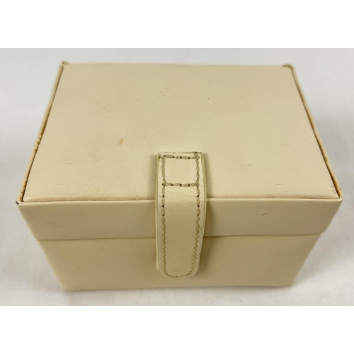 1057 - A small modern cream faux leather jewellery box with lift out tray containing a collection of silver... 