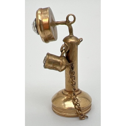 1070 - A 9ct gold pendant/charm in the shape of a candlestick telephone. Set with 2 clear stones. Hallmarks... 