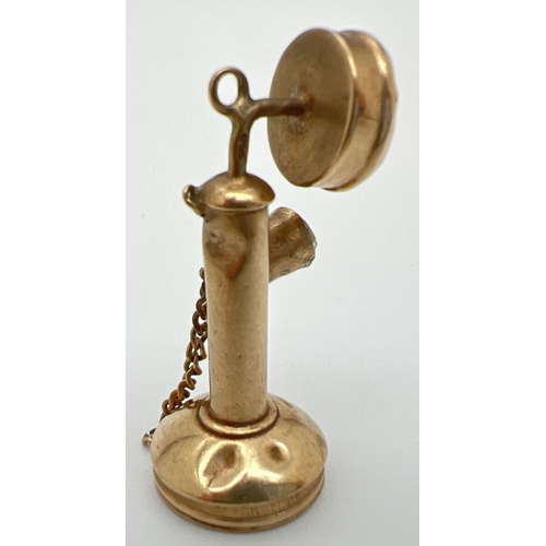 1070 - A 9ct gold pendant/charm in the shape of a candlestick telephone. Set with 2 clear stones. Hallmarks... 