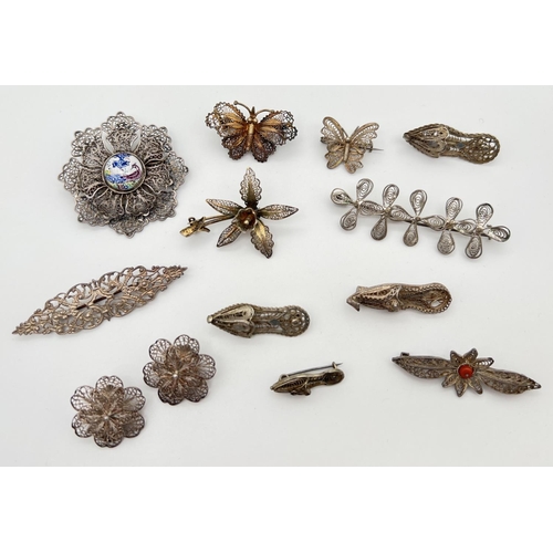 1074 - A collection of 11 assorted vintage white metal filigree brooches together with a pair of clip on ea... 