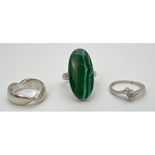 1082 - 3 silver dress rings. A twist design band ring, a ring set with a large oval cut malachite stone and... 