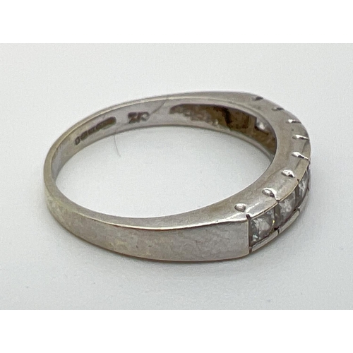 1086 - A 9ct white gold half eternity ring, channel set with 7 square cut cubic zirconia stones. Gold  mark... 