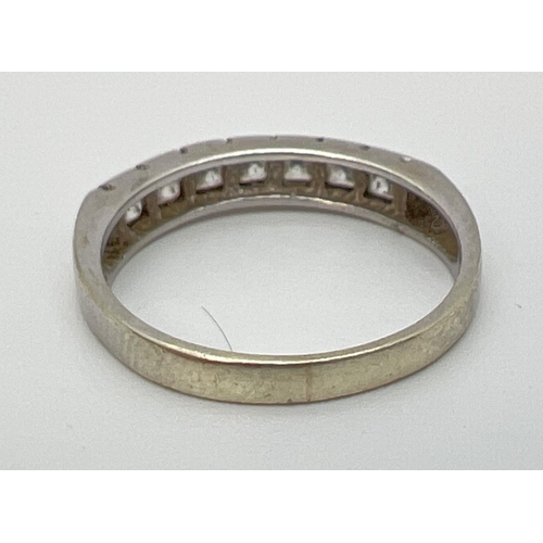 1086 - A 9ct white gold half eternity ring, channel set with 7 square cut cubic zirconia stones. Gold  mark... 