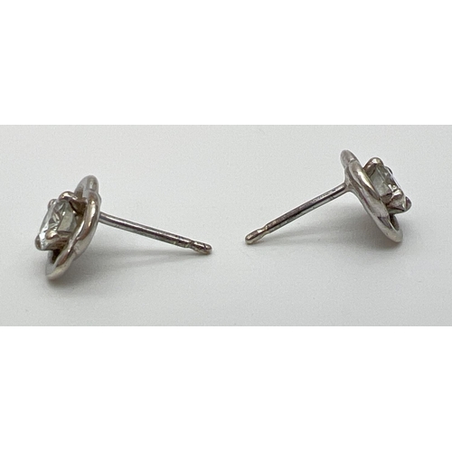 1093 - A pair of 9ct white gold modern design moissanite set stud earrings. Each earring set with a .25ct r... 