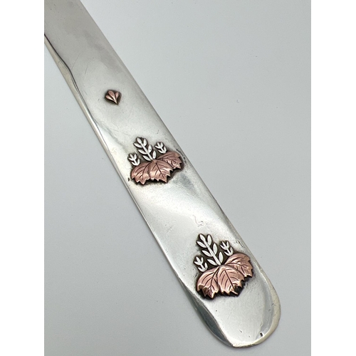 1140 - A vintage Tiffany & Co silver and mixed metal letter opener with embossed floral design to front. St... 